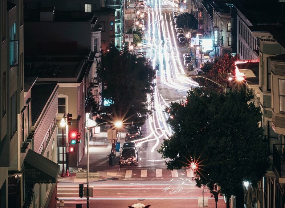 hooded-figure-sits-on-city-street-hill_925x
